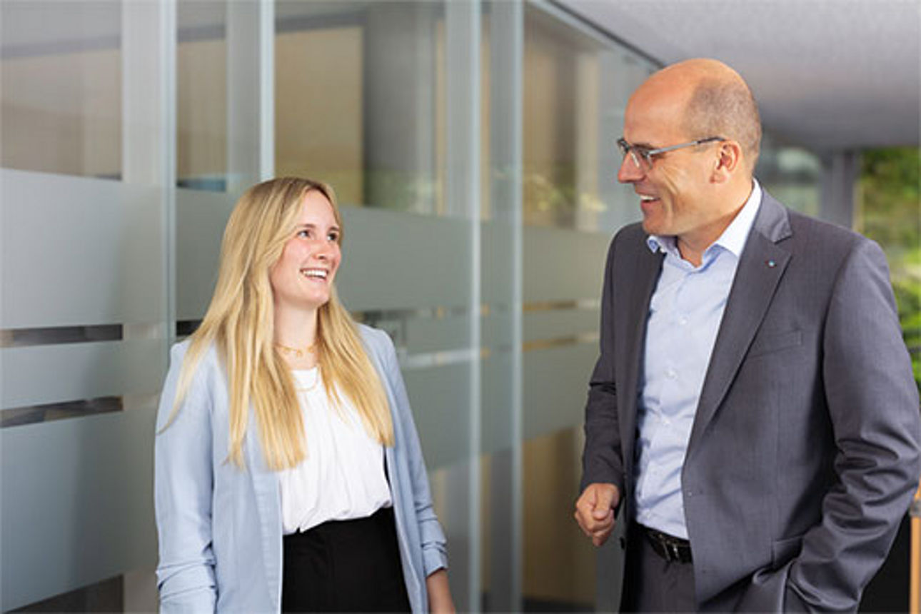 Frau und Mann stehen lächelnd in einem Flur