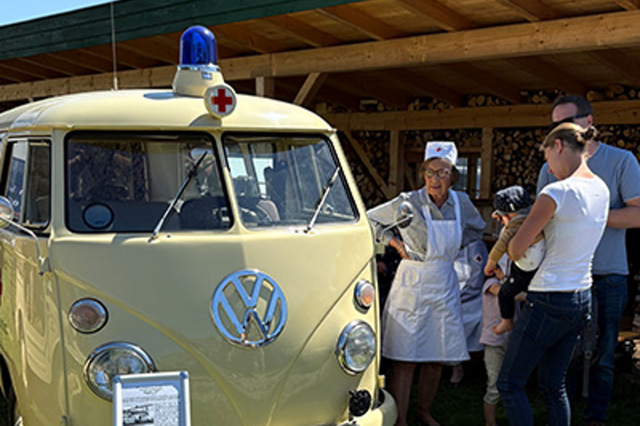 Zwei Frauen stehen an einem historischen Fahrzeug