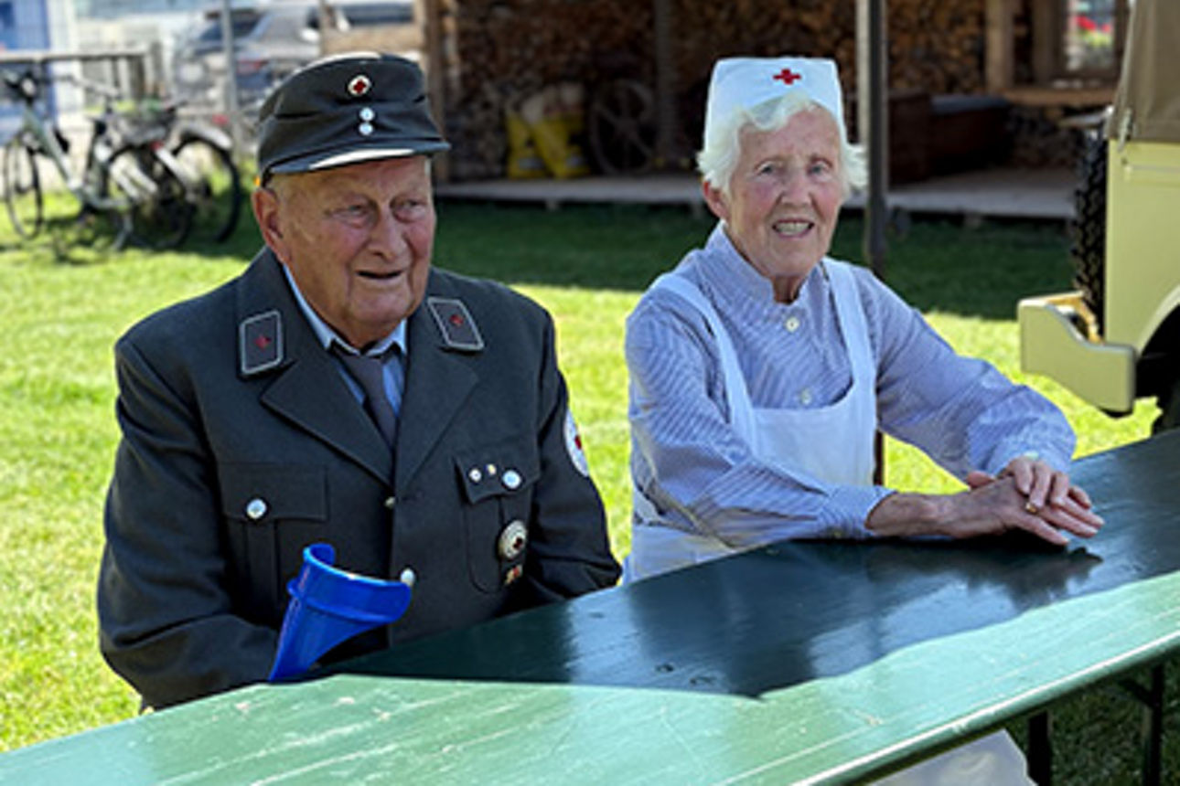 Ein Mann und eine Frau sitzen in historischer Kleidung an einem Tisch.