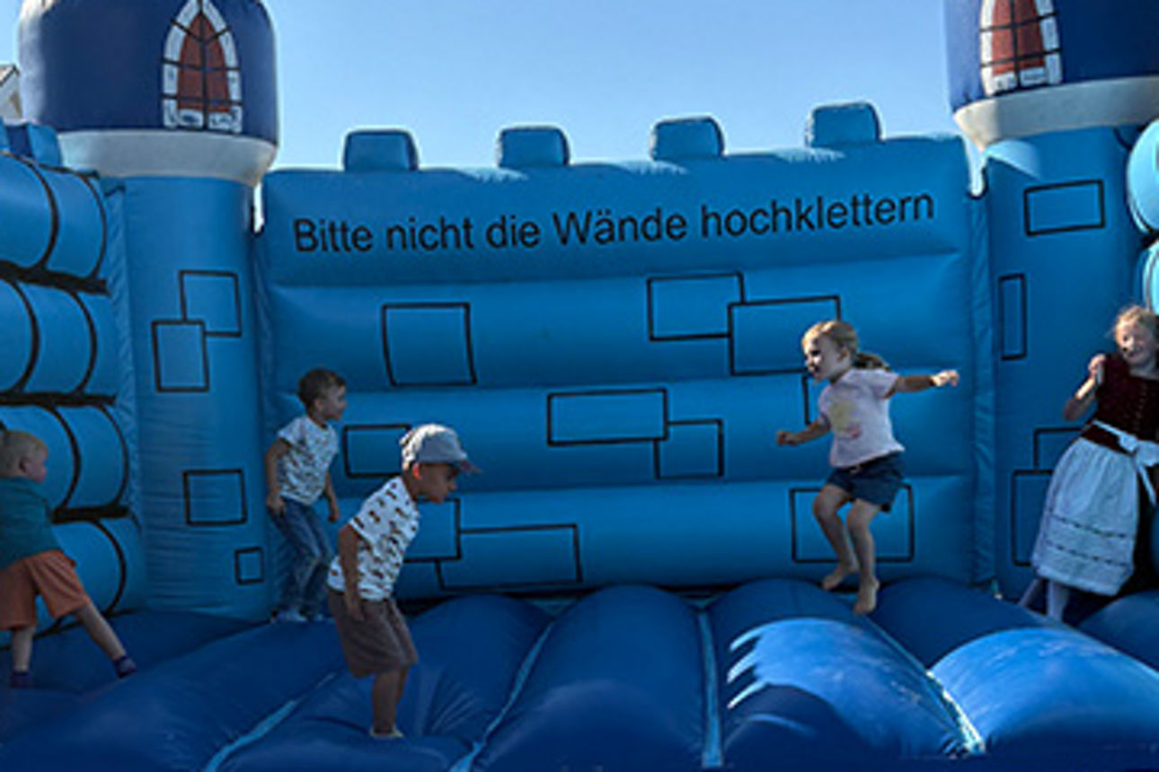Kinder hüpfen auf einer Hüpfburg und haben Spaß