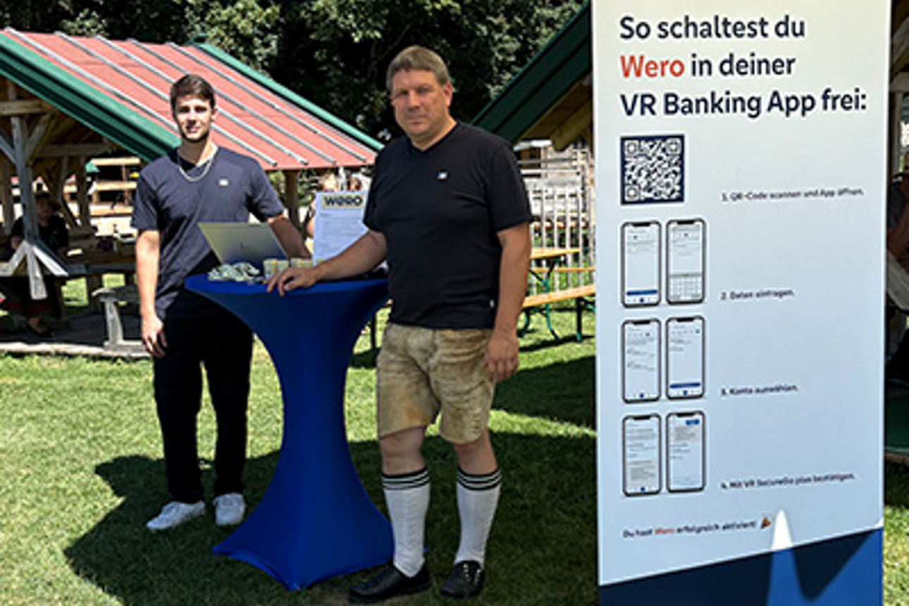 Zwei Männer stehen an einem Wero-Infostand.