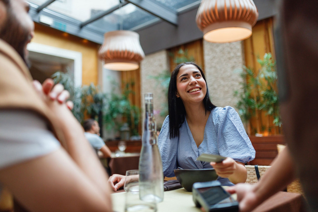 junge Frau zahlt im Restaurant mit ihrer Karte