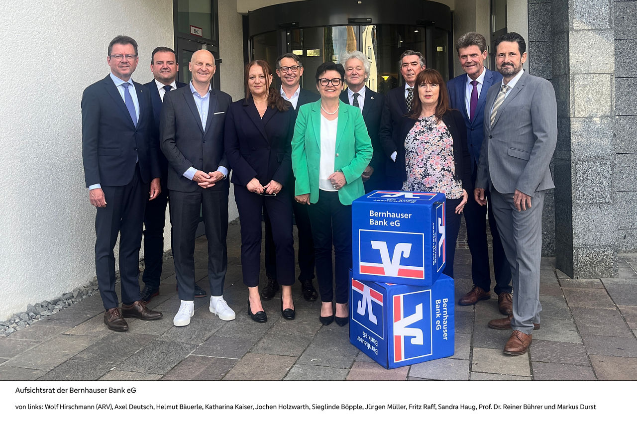 Eine bunte Gruppe von Menschen versammelt sich vor einer Bank