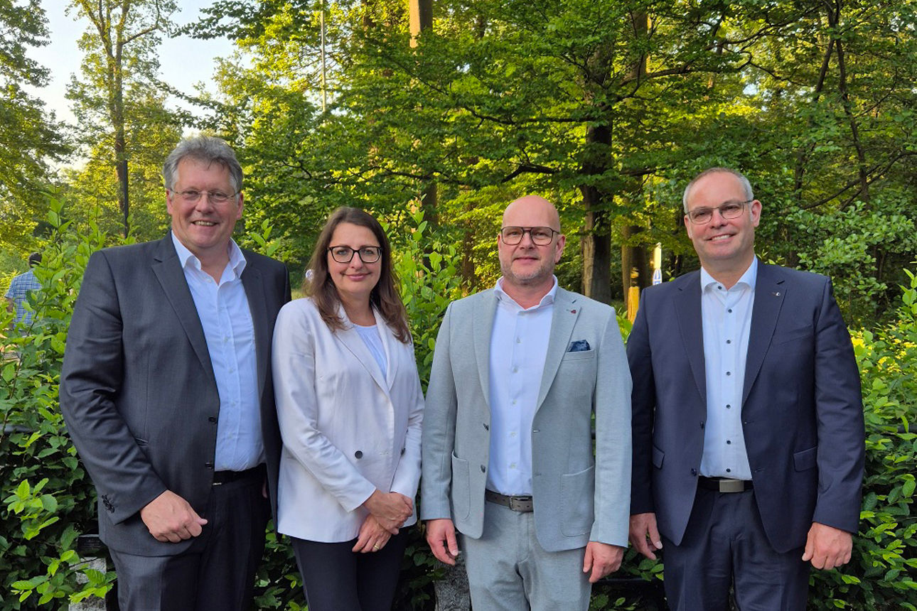 4 Persoen stehen vor Bäumen