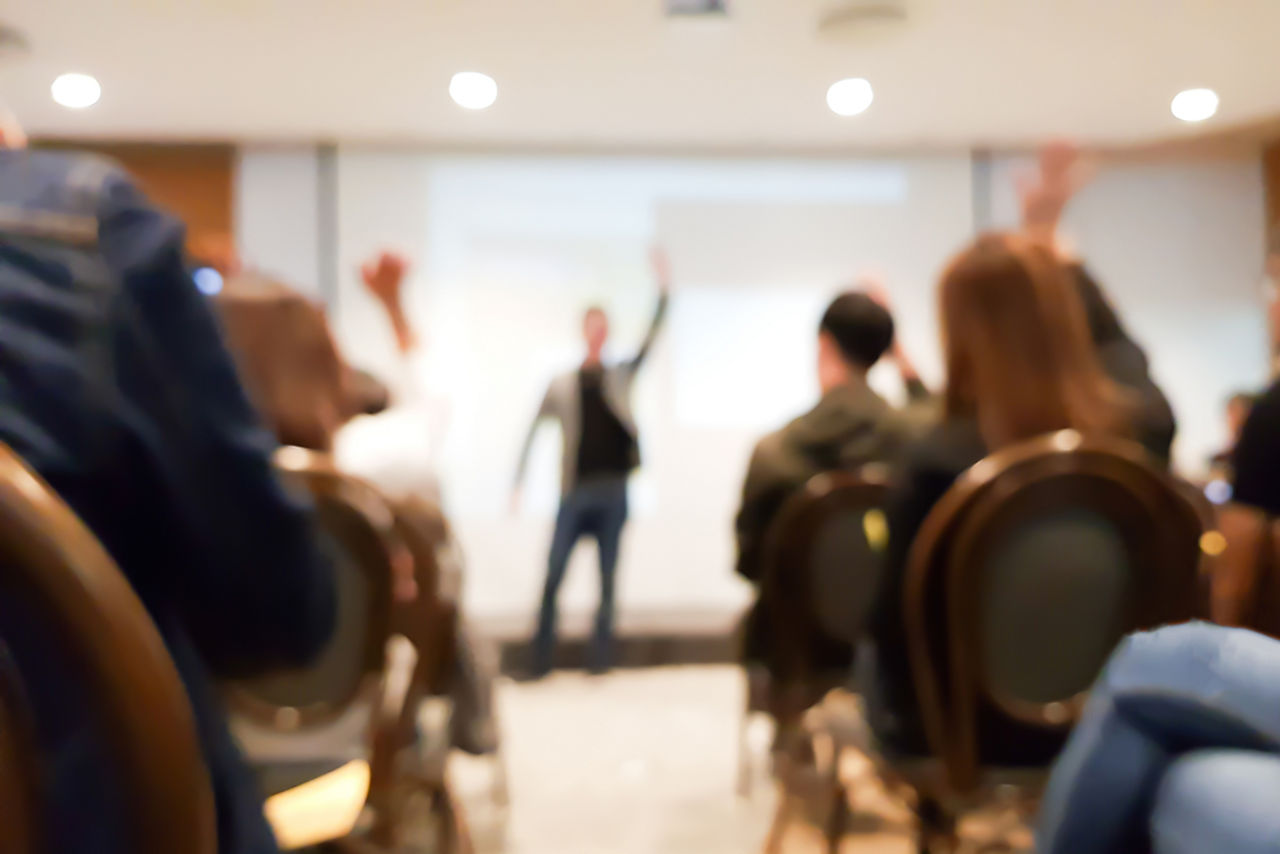 Verschwommene Gruppe von Menschen in Kongress-Saal bei Abstimmung
