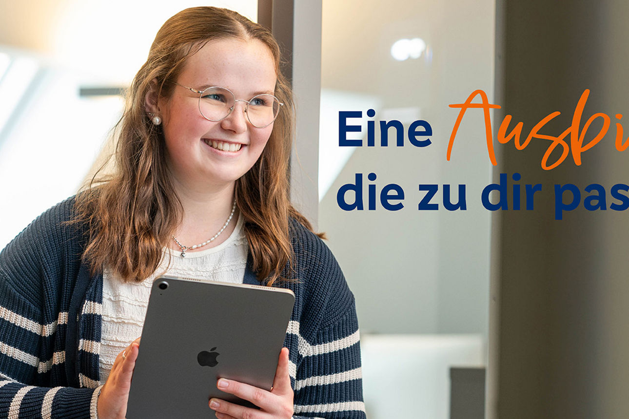 Eine Frau sitzt mit Laptop und Kaffee an einem Tisch und hält ihre goldene girocard in den Händen