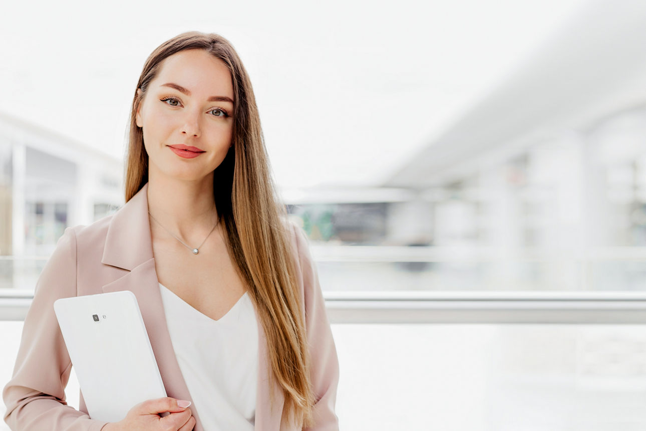 Junge Frau schaut mit verschränkten Armen in eine Kamera