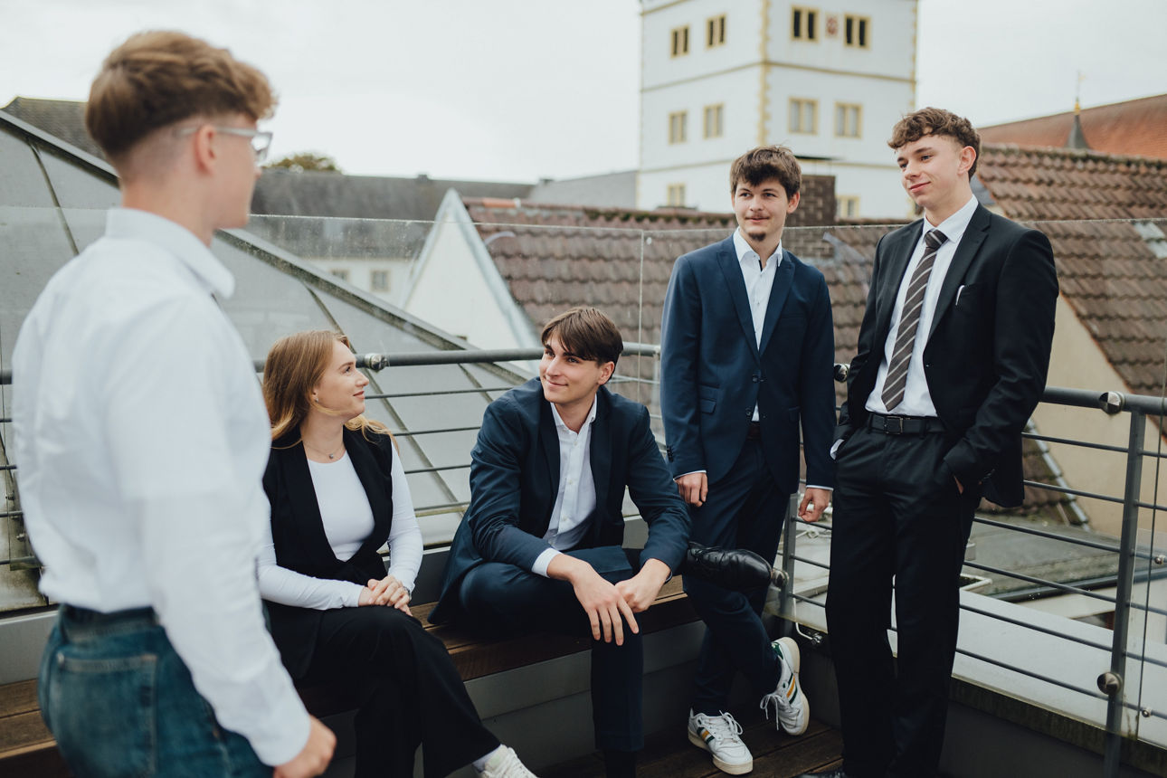 Eine Gruppe junger Menschen steht auf einer Dachterrasse