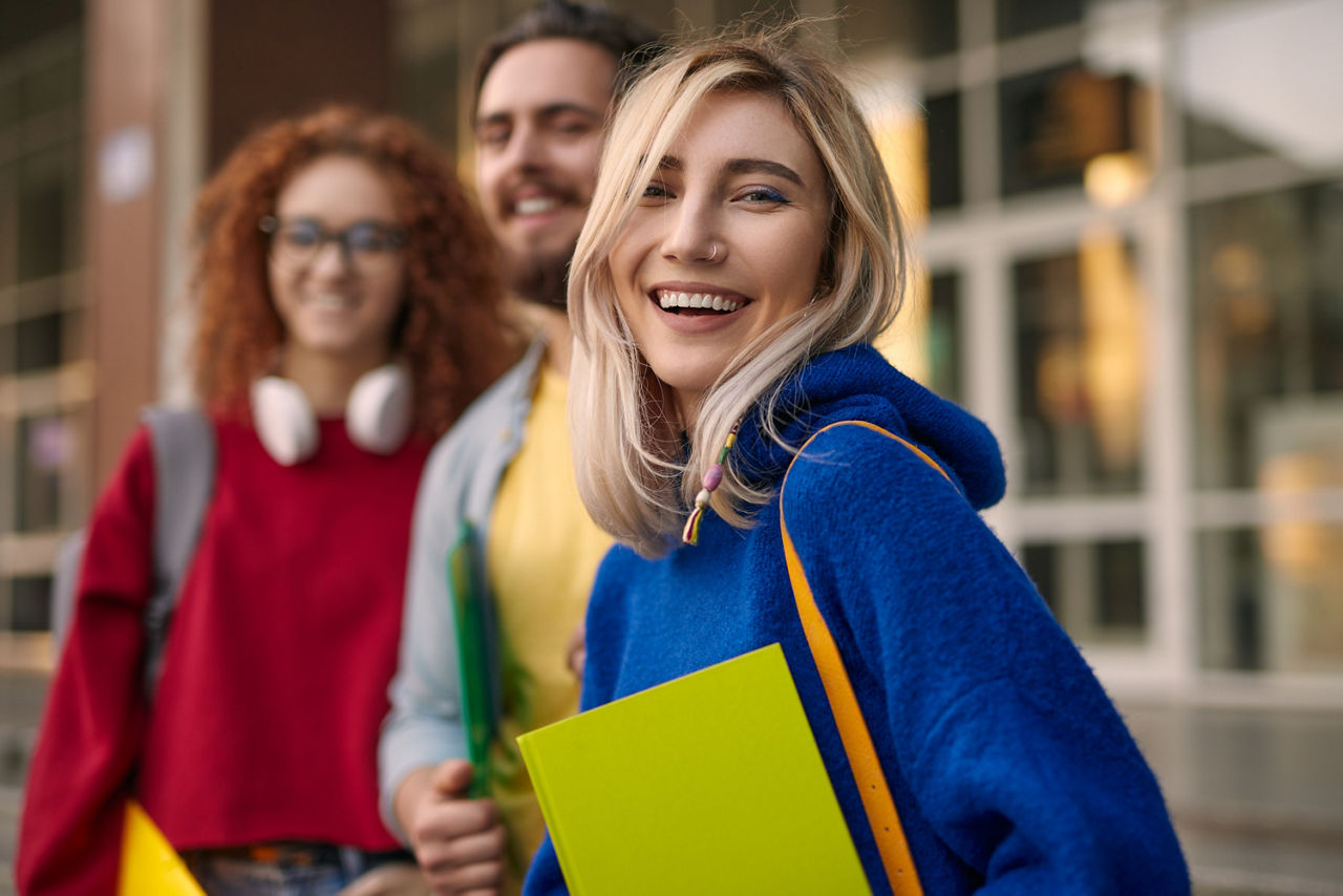 Glückliche blonde Frau in der Nähe von Klassenkameraden