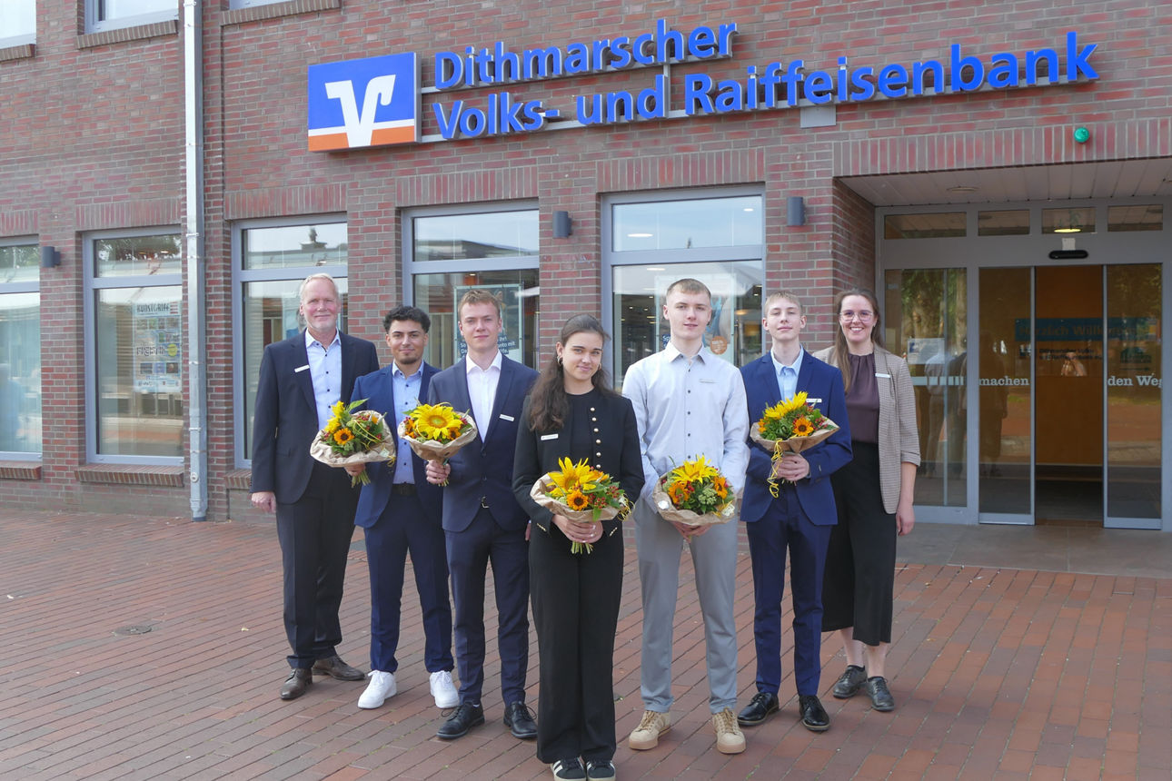 Menschen bilden ein V und lächeln in die Kamera