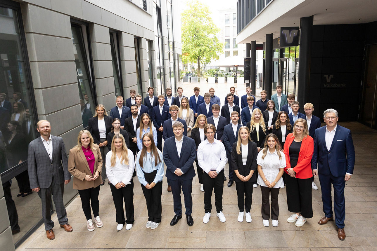 Eine Gruppe junger Menschen steht vor einem Bankgebäude