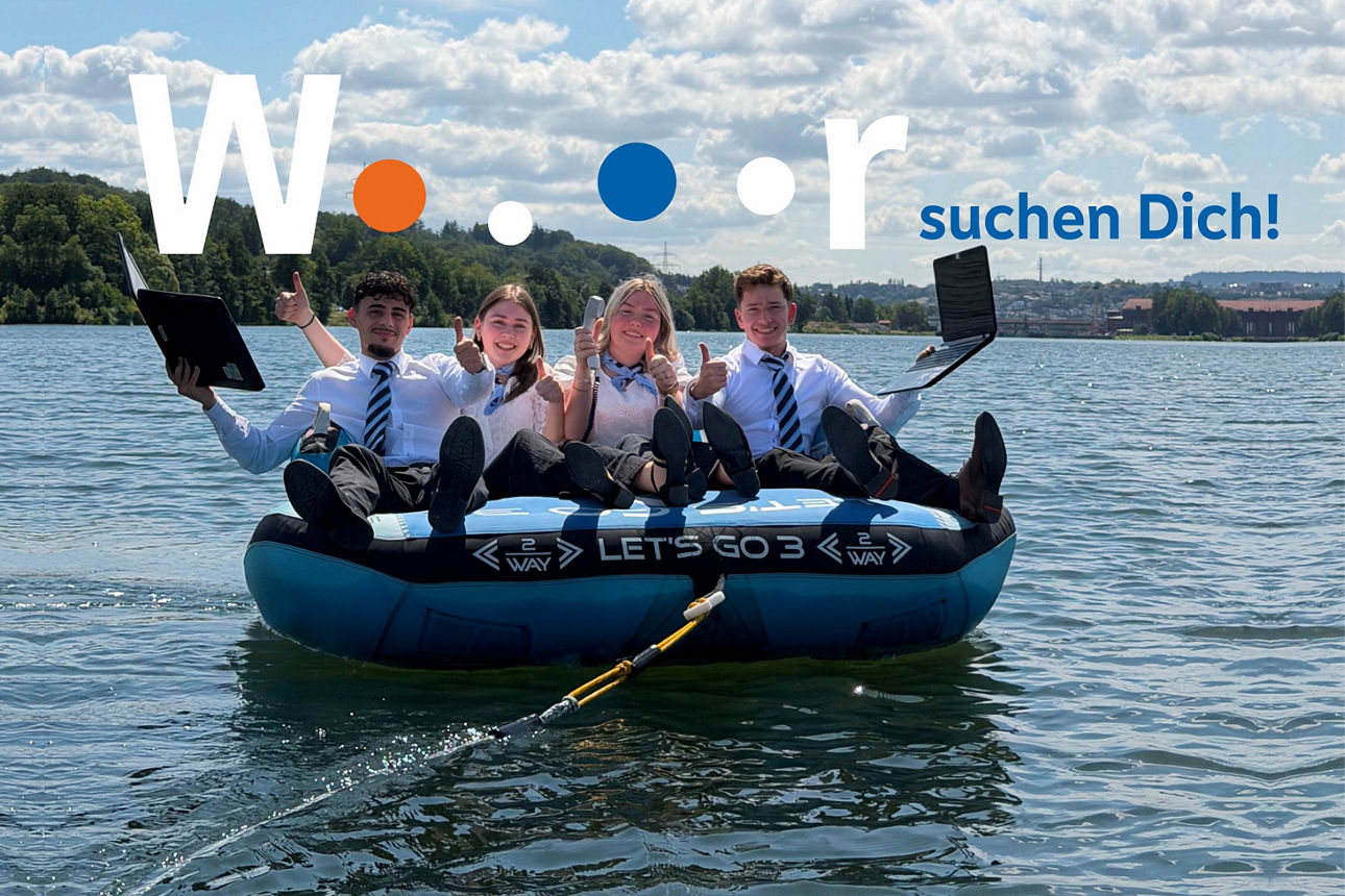 Vier Bankauszubildende mit Laptop und Telefon auf Luftkissen in der Donau, über Ihnen das Text „Wir suchen Dich!“.