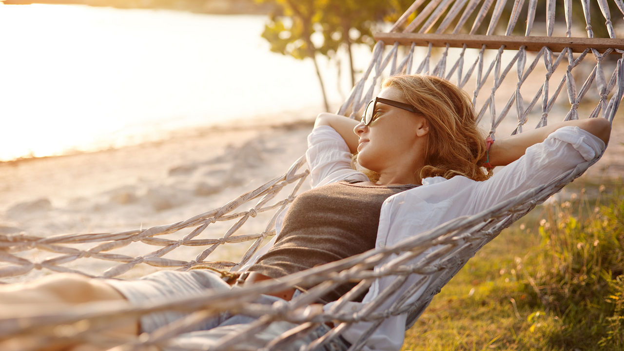 Frau in einer Hängematte am Strand