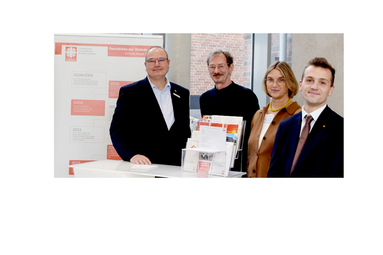 Vier Personen (drei Männer und eine Frau) an einem Stehtisch.