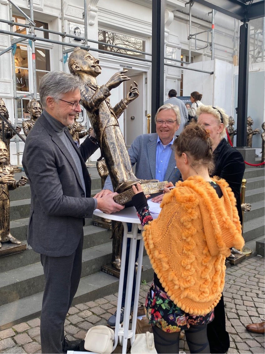 zwei Männer, zwei Frauen begutachten die Statue Humperdinck