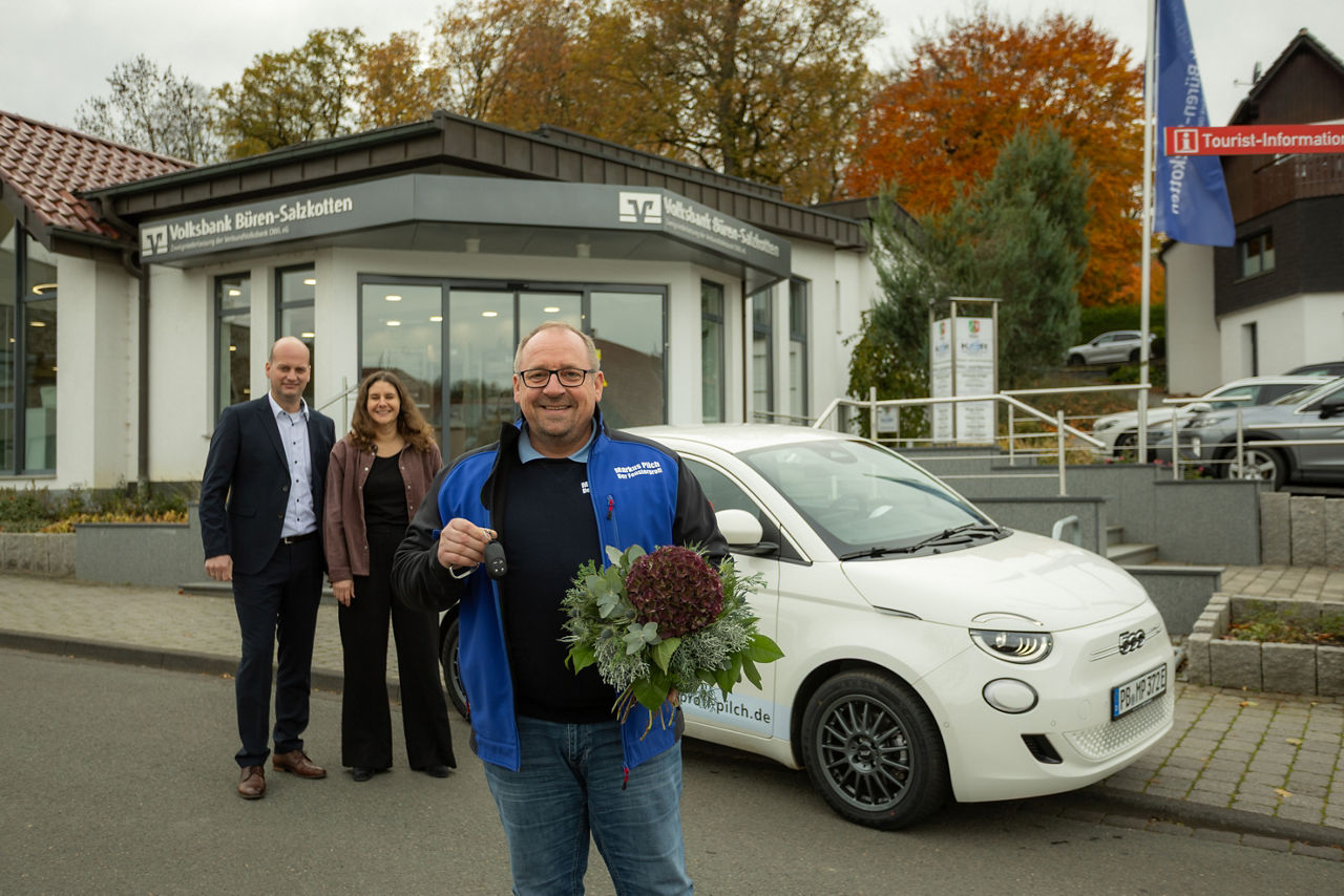Bankvorstand Ansgar Käter und zwei Vertreter der Polizei mit einem Schild zur Aktion „Geschockt am Telefon? – Auflegen!“ 