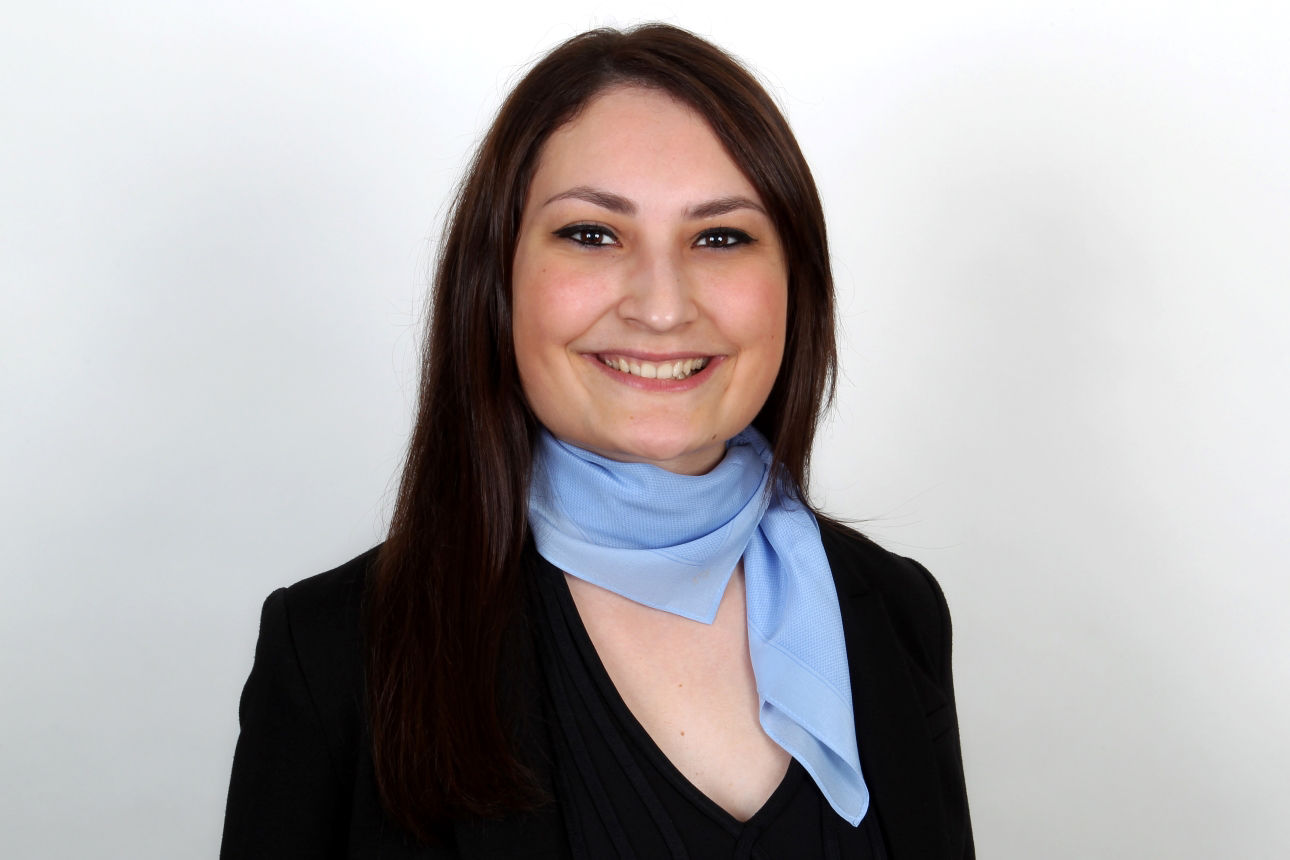 Eine lächelnde Frau schaut in die Kamera.