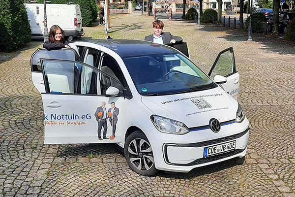 Ein weißer Volkswagen Up! ist auf einer Kopfsteinpflasterstraße geparkt.