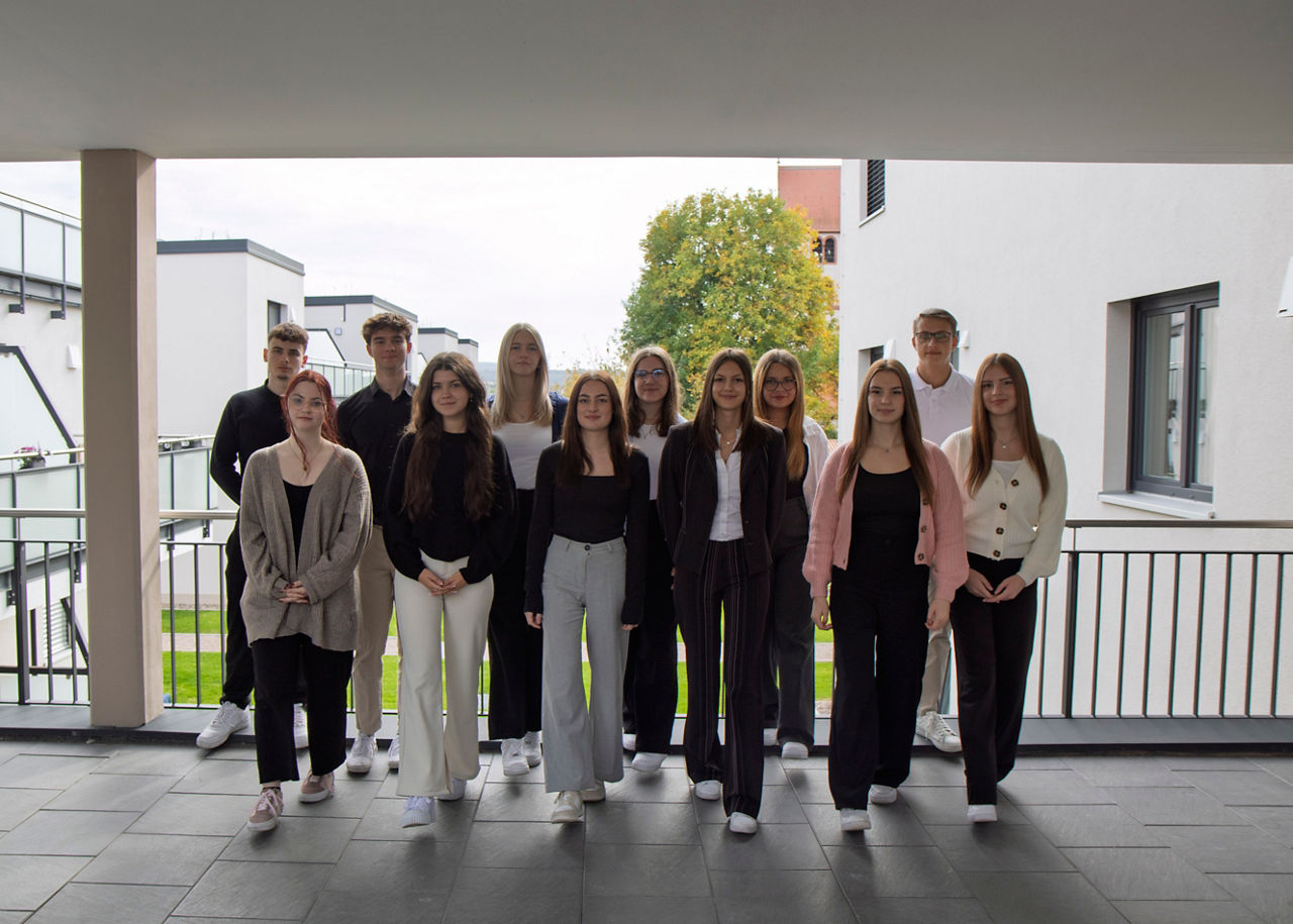 zwölf Azubis stehen in einer Gruppe zusammen