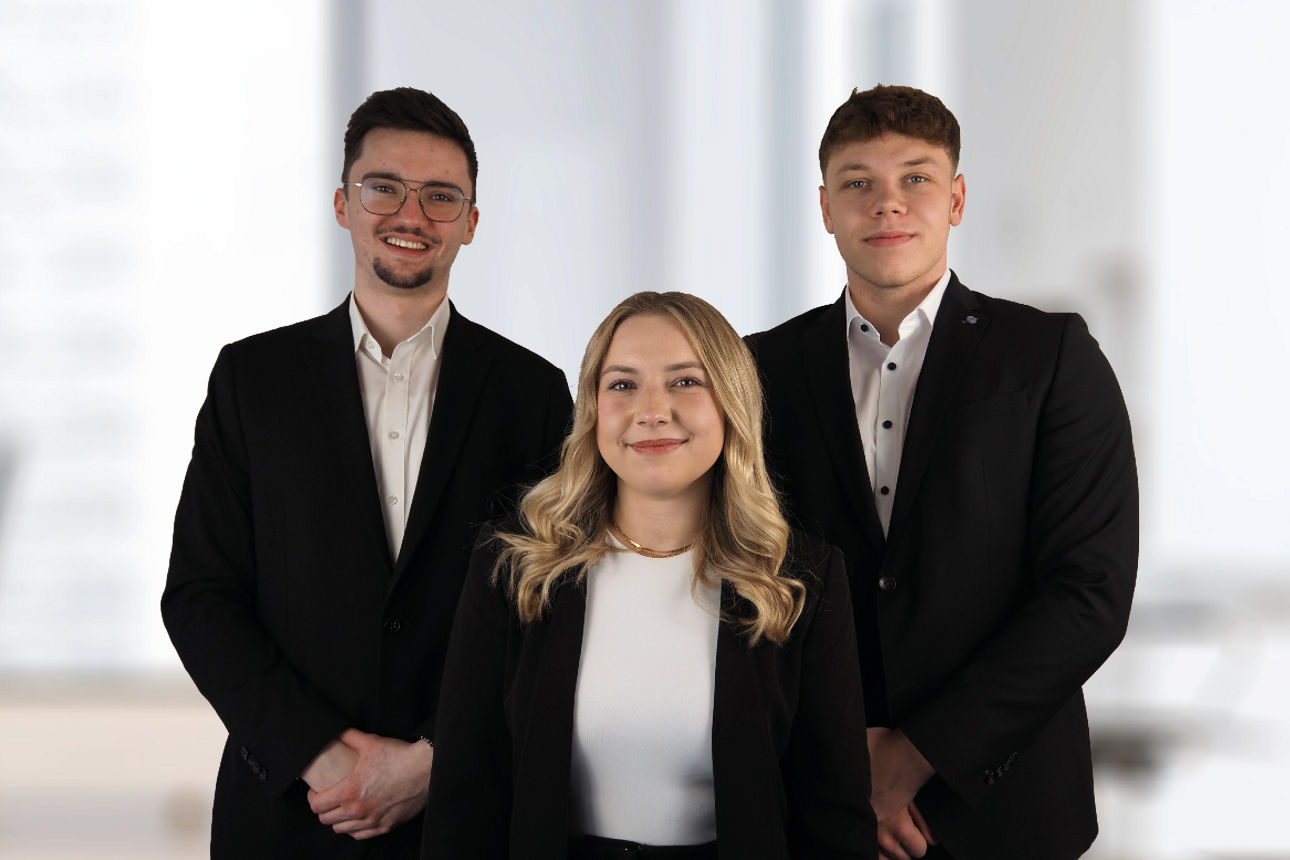 Drei Auszubildende lächeln in die Kamera