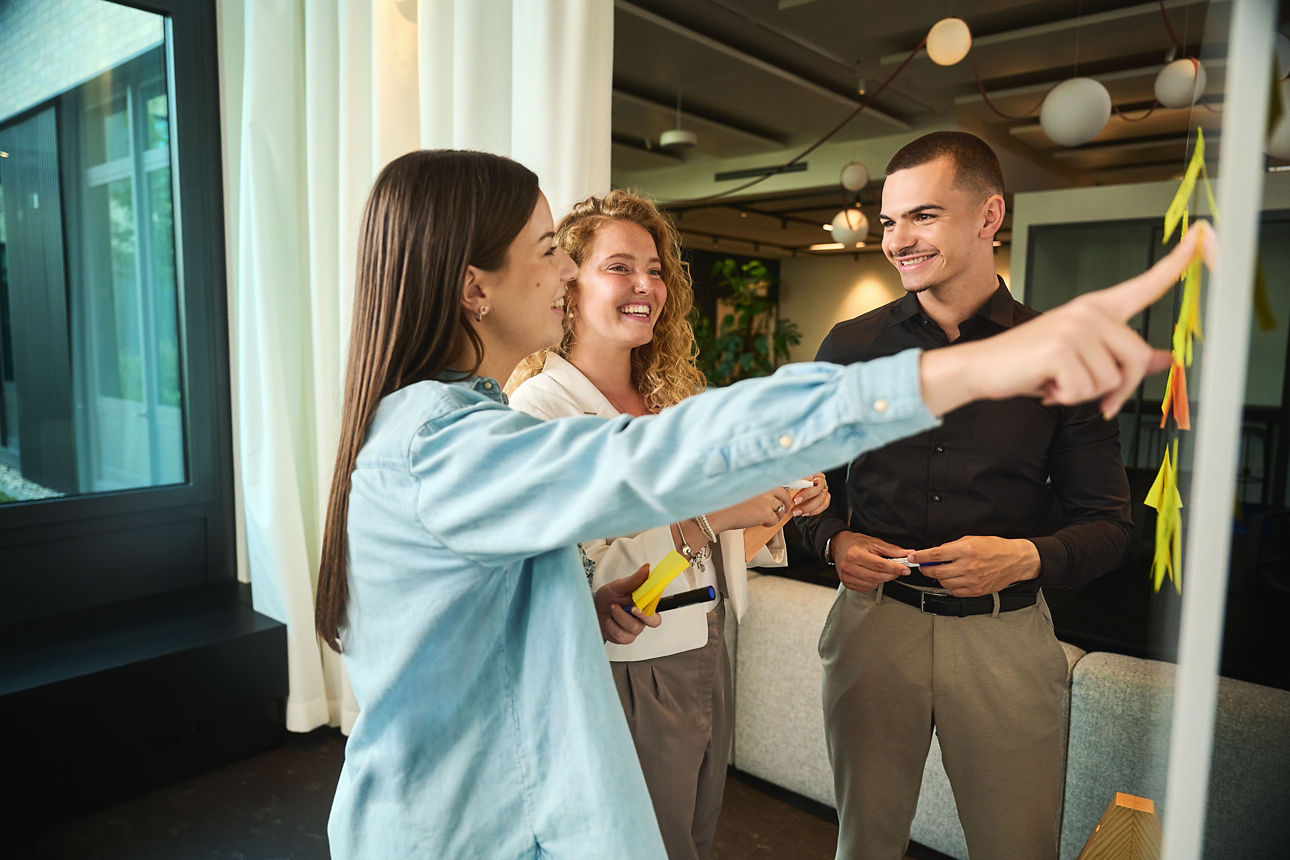 Drei Personen stehen vor einer Metaplanwand