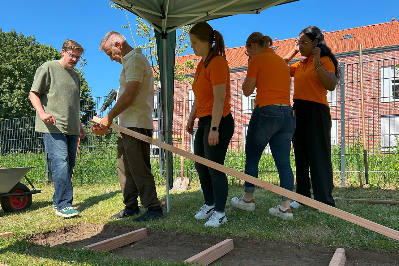 Fünf Personen arbeiten am Grundgerüst des Barfußpfades. 