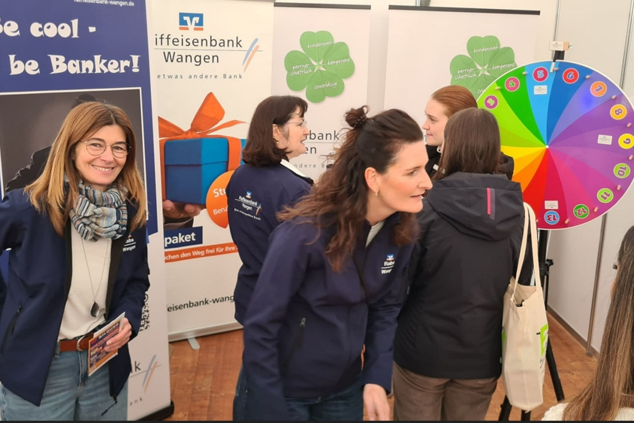 Beratung am Messestand der Raiffeisenbank mit Glücksrad und persönlichen Gesprächen.