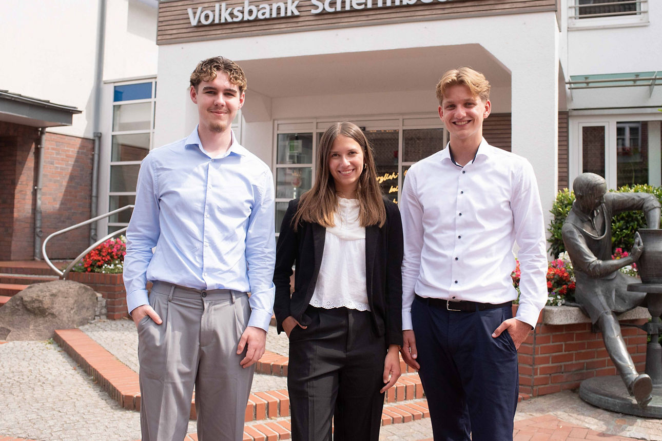 Unsere neuen Auszubildenden vor der Bank: Leon Butler, Marie Terhardt und Henning Berger