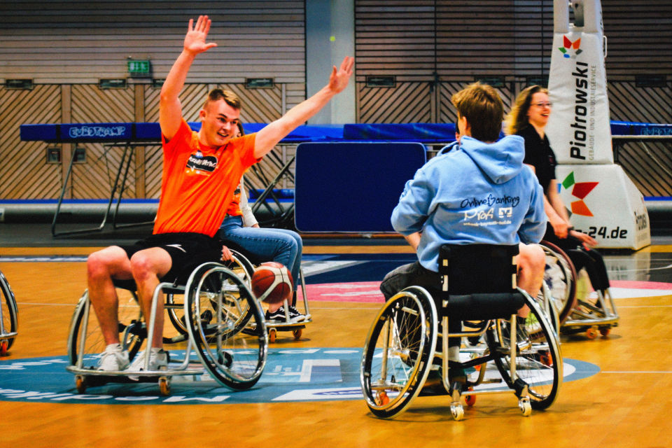 Zwei junge Männer spielen Rollstuhlbasketball