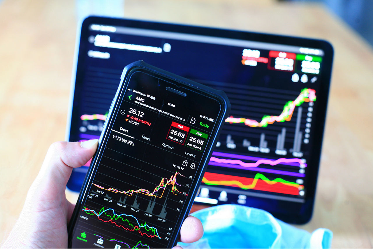 Bildschirm von einem Handy und einem Tablet mit aktuellen Börseninformationen und Börsencharts