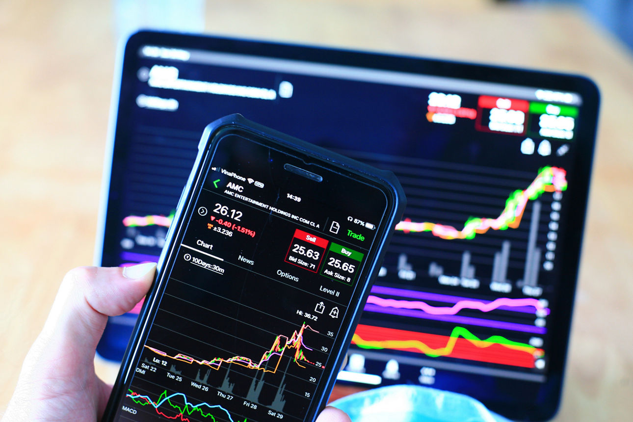 Bildschirm von einem Handy und einem Tablet mit aktuellen Börseninformationen und Börsencharts