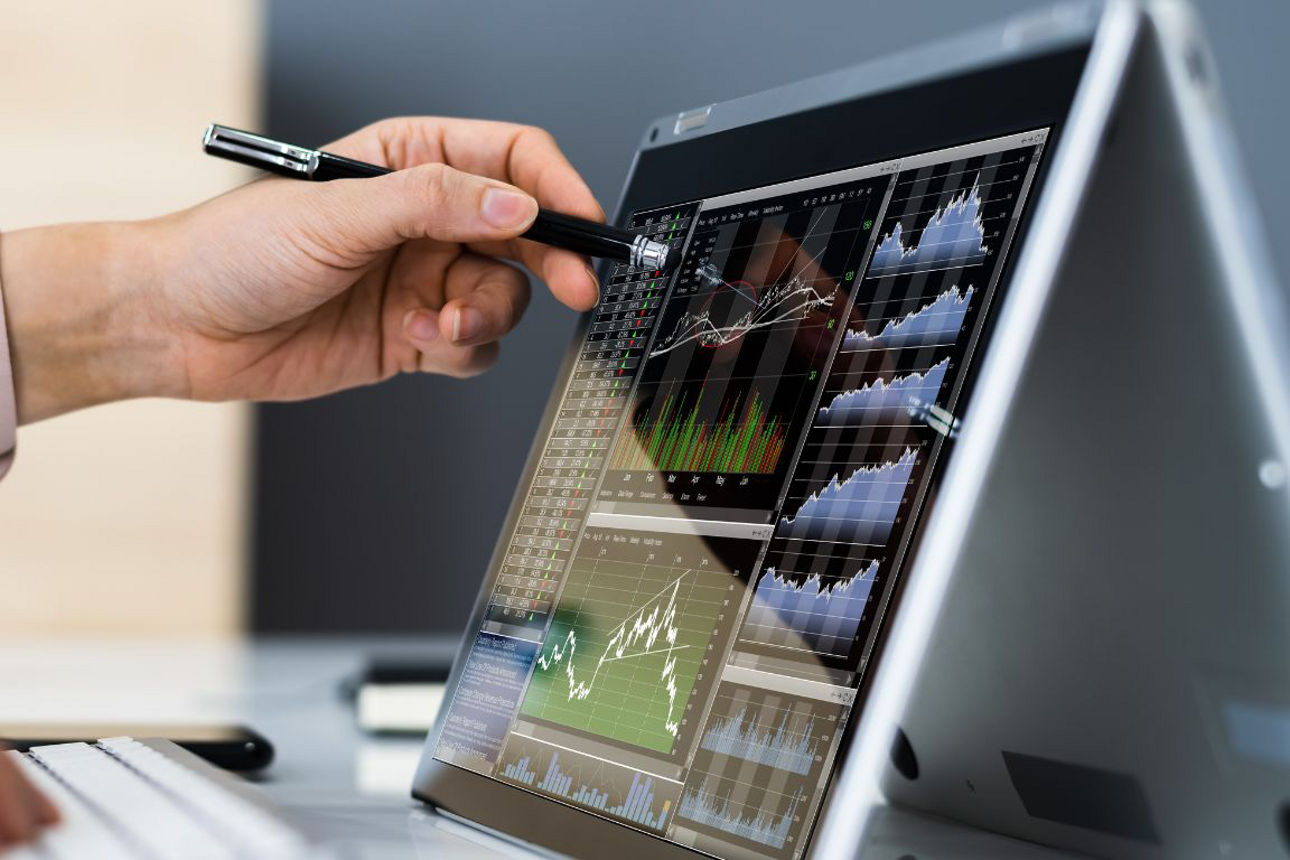 Hand zeigt auf Laptop mit Börsennachrichten