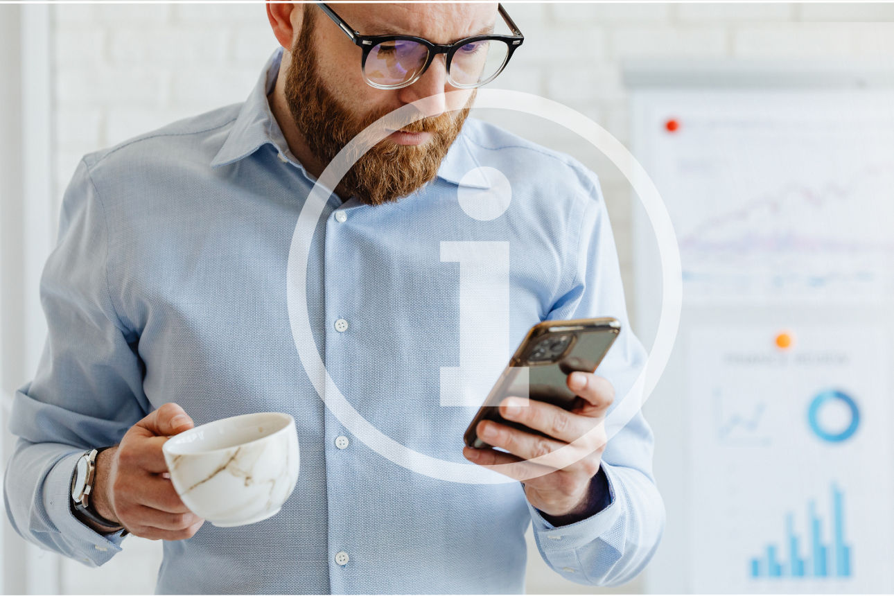 Eine Person in einem hellen Mantel und rotem Schal steht auf einer Rolltreppe und schaut auf ihr Smartphone