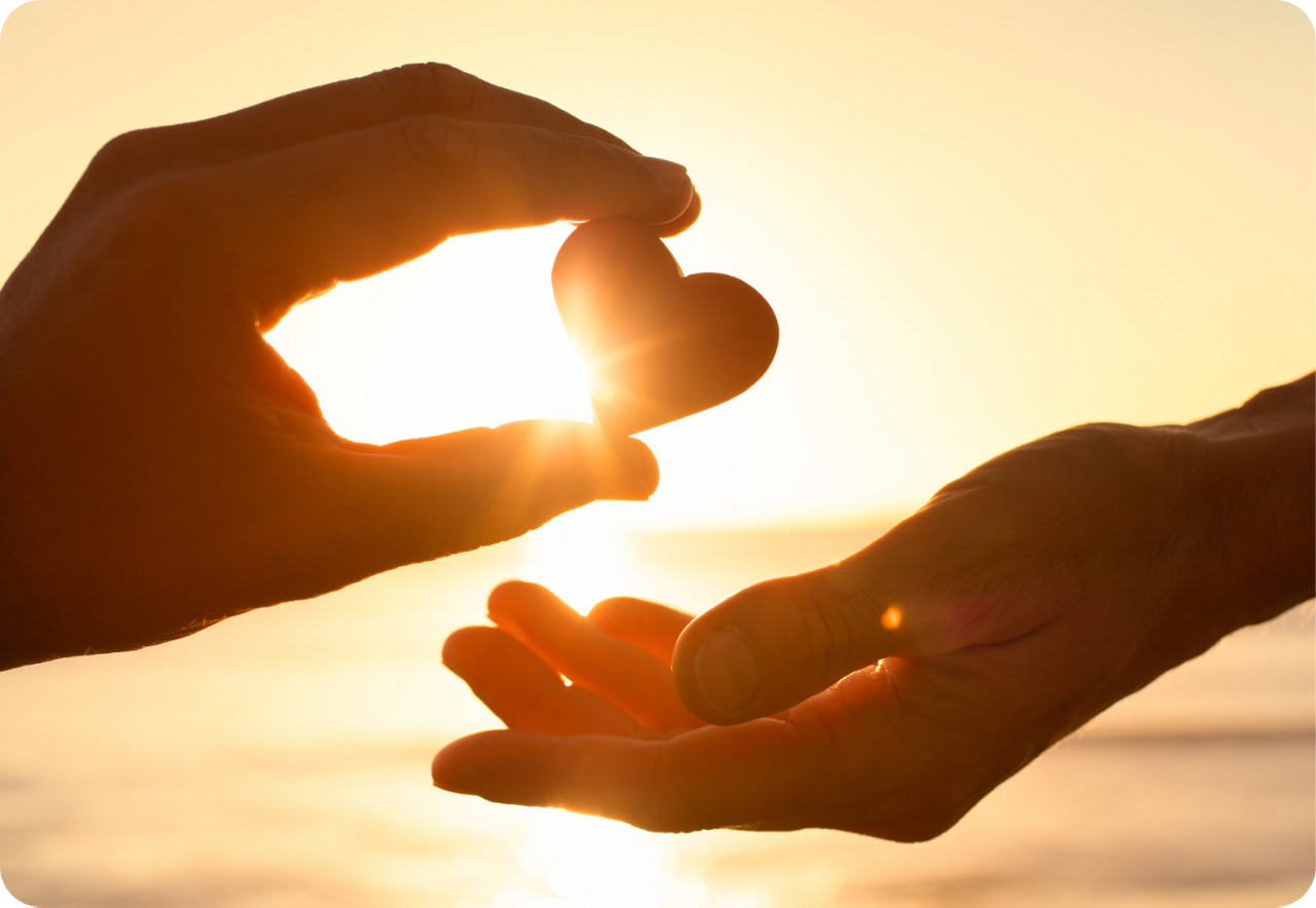 Eine Hand übergibt der anderen Hand ein Herz