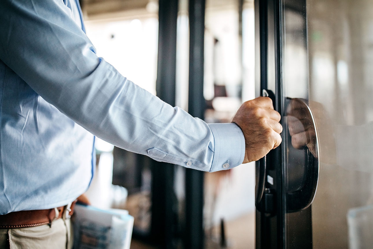 Person öffnet die Tür zu einem Büro