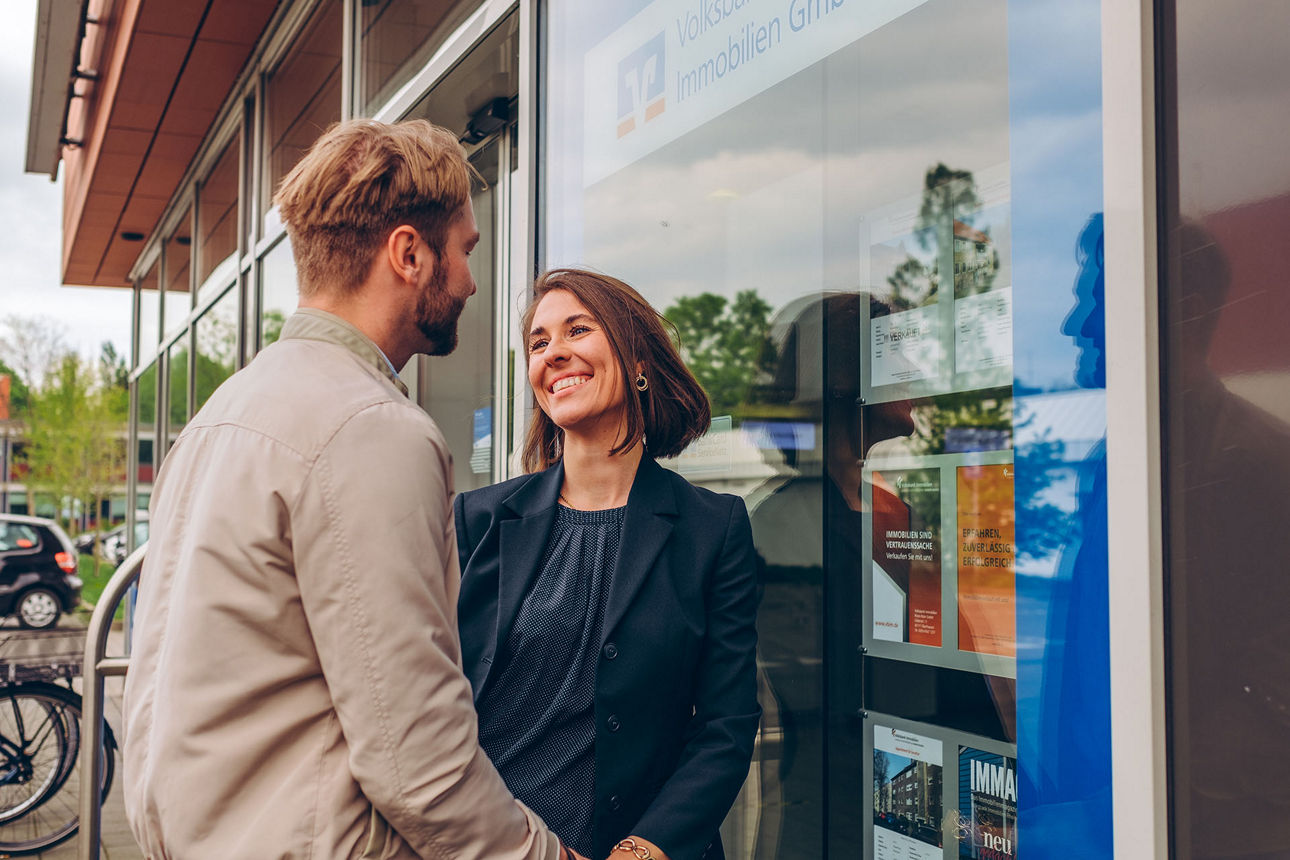 Ein junges Paar steht vor einer Geschäftsstelle der Volksbank Rhein-Ruhr