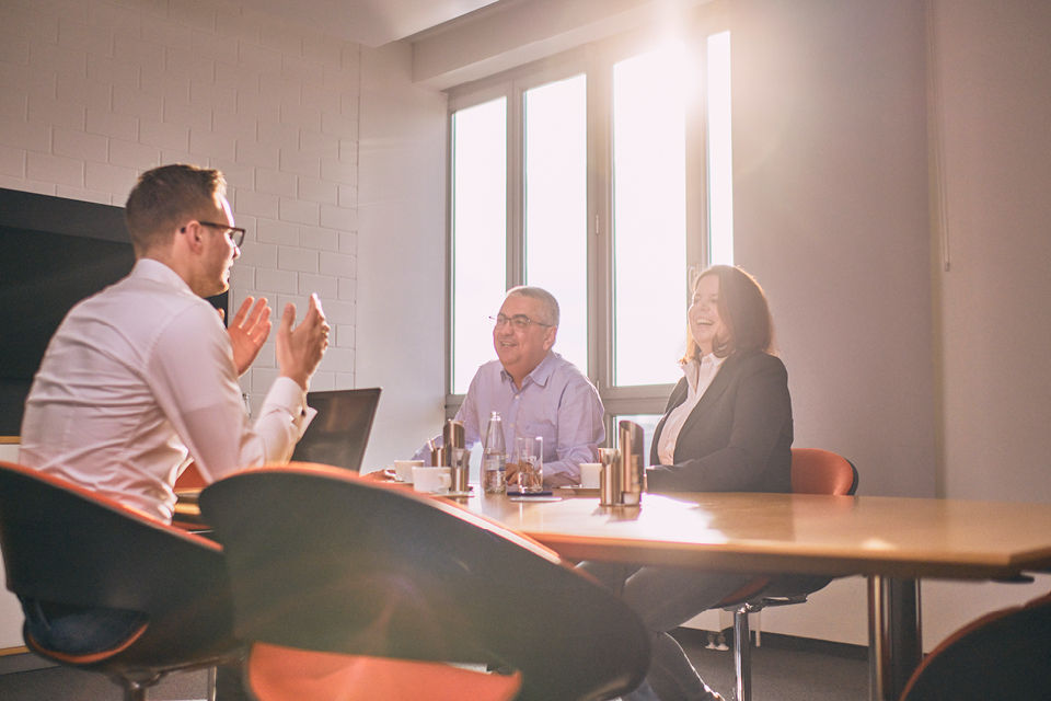 Eine Frau und zwei Männer in einem Beratungsgespräch