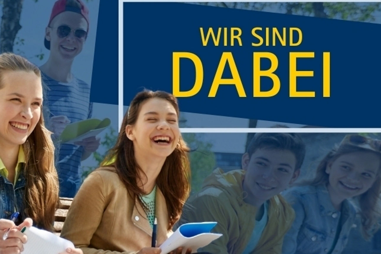 Eine Gruppe junger Leute sietzen lachend auf einer Bank