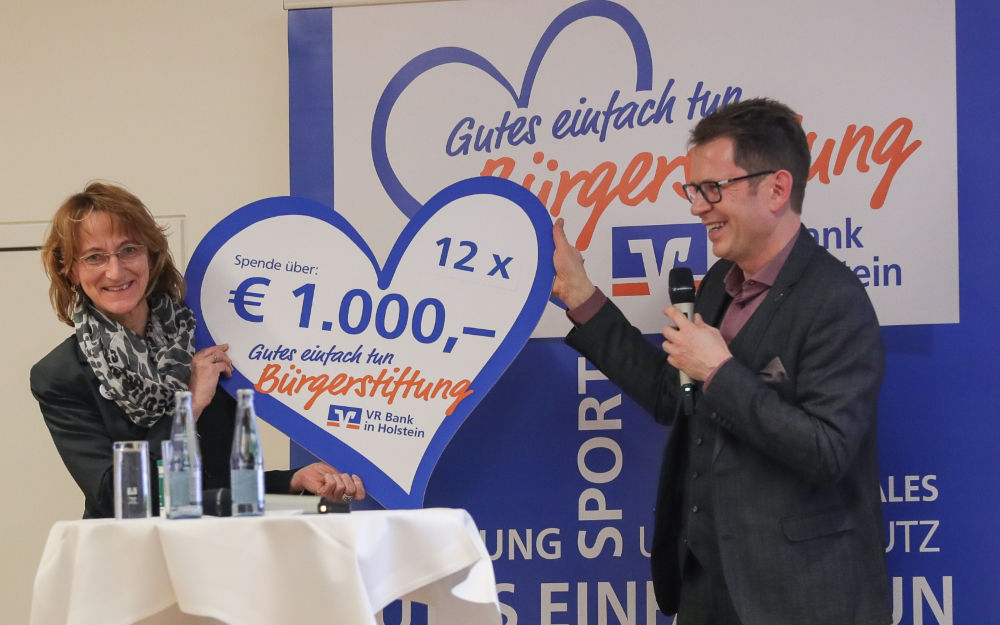 Anja Radtke nimmt ein Spendenherz von Uew Augustin entgegen