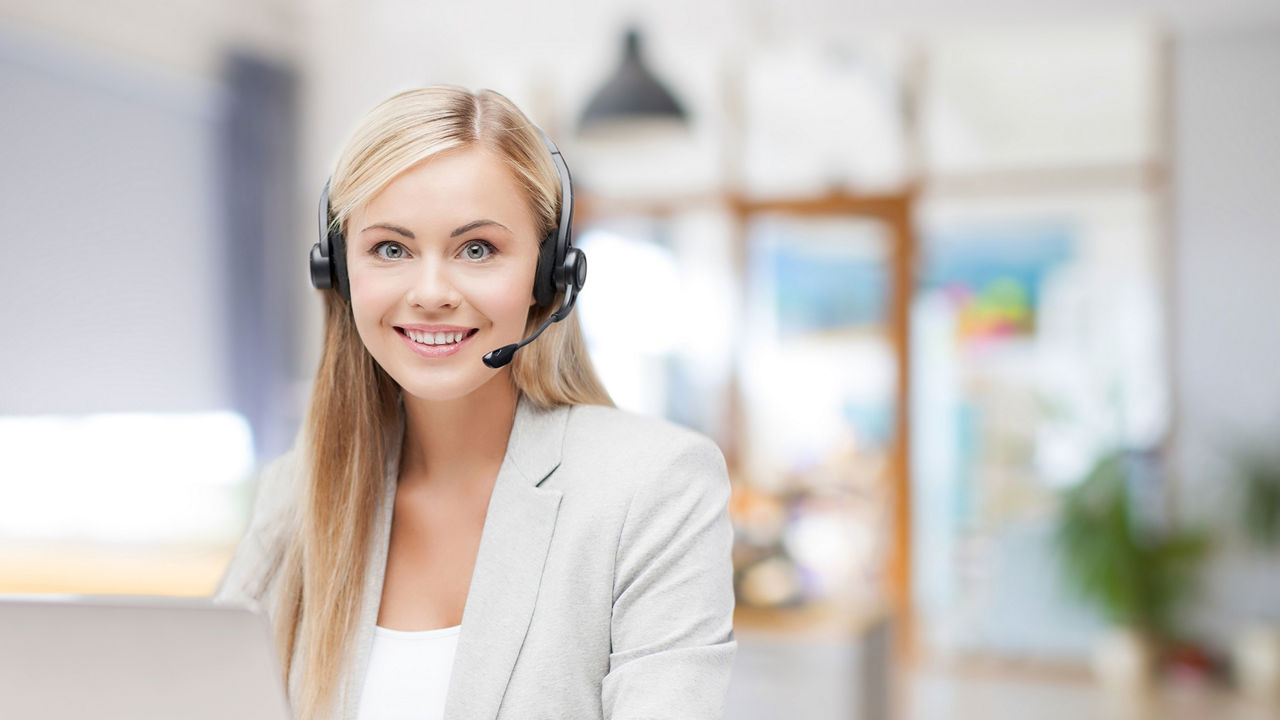 Blonde junge Frau mit einen Headset lächelt frontal