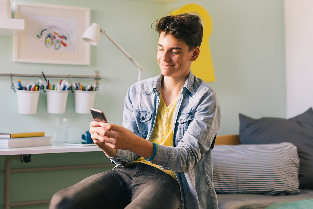 Junger Mann mit seinem Handy in der Hand freut sich über die Push-Benachrichtigung
