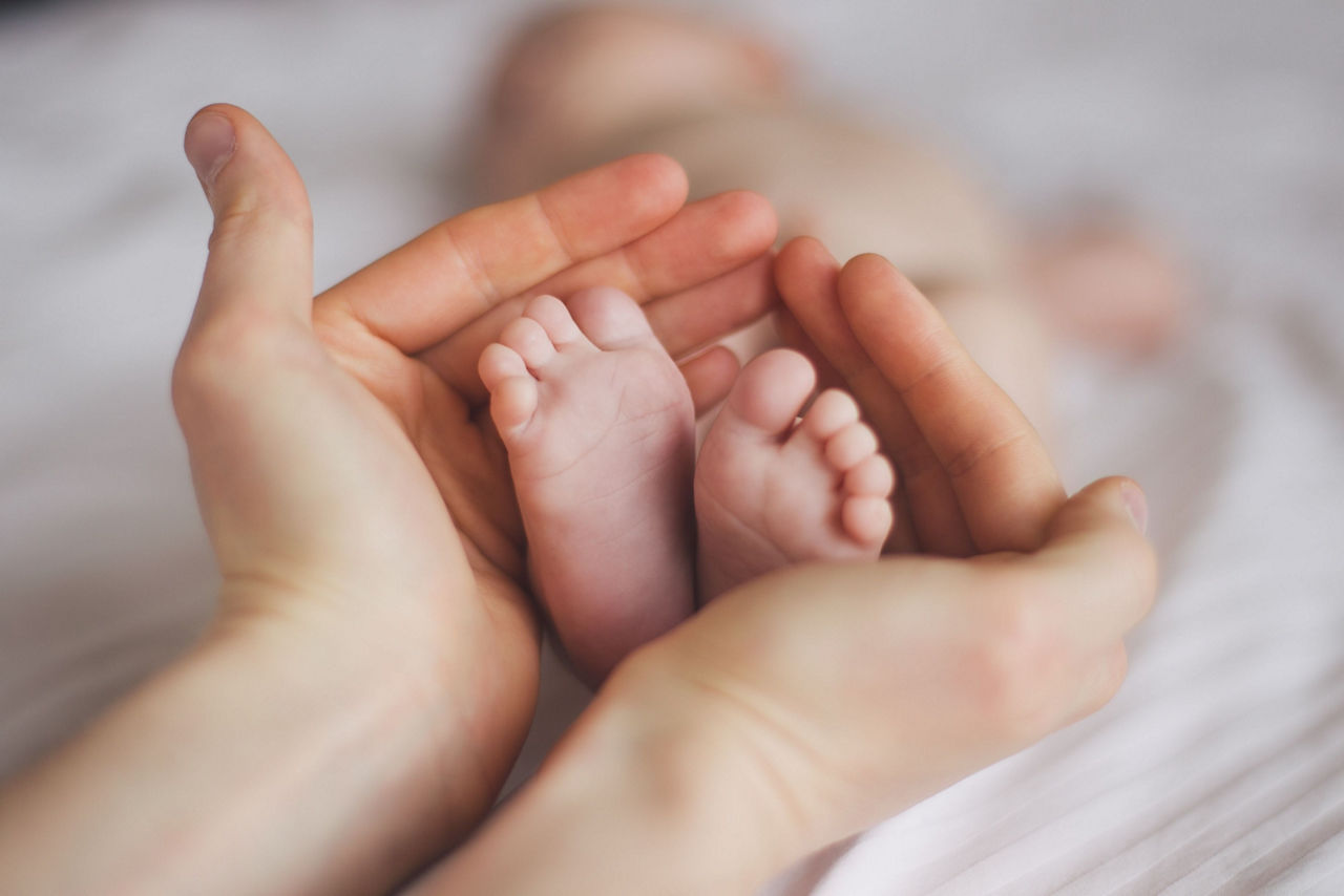 Babyfüße in der Hand der Mutter