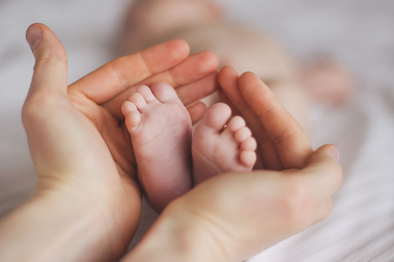 Babyfüße in der Hand der Mutter