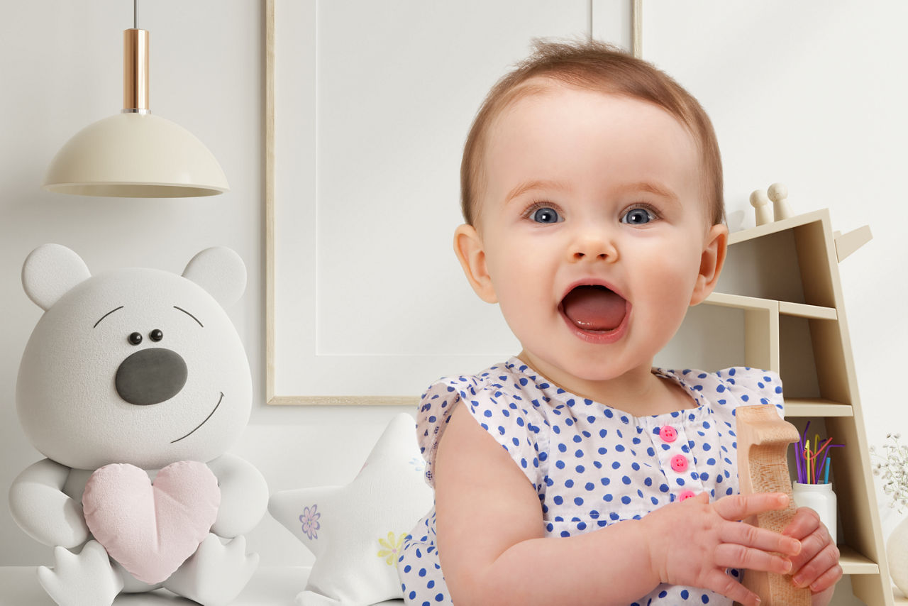 Baby glücklich mit Spielzeug in der Hand in Spielzimmer
