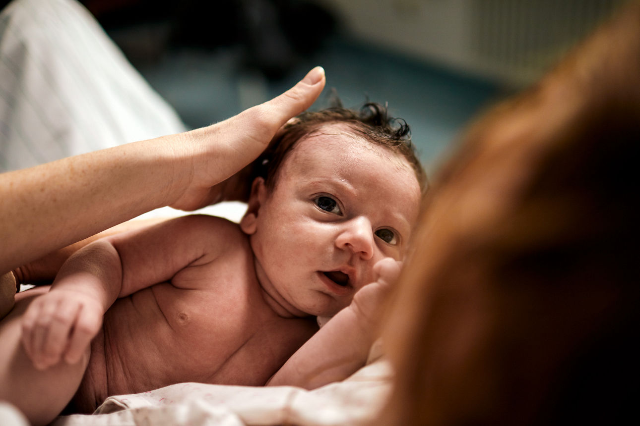 Baby nach der Geburt im Arm der Mutter 