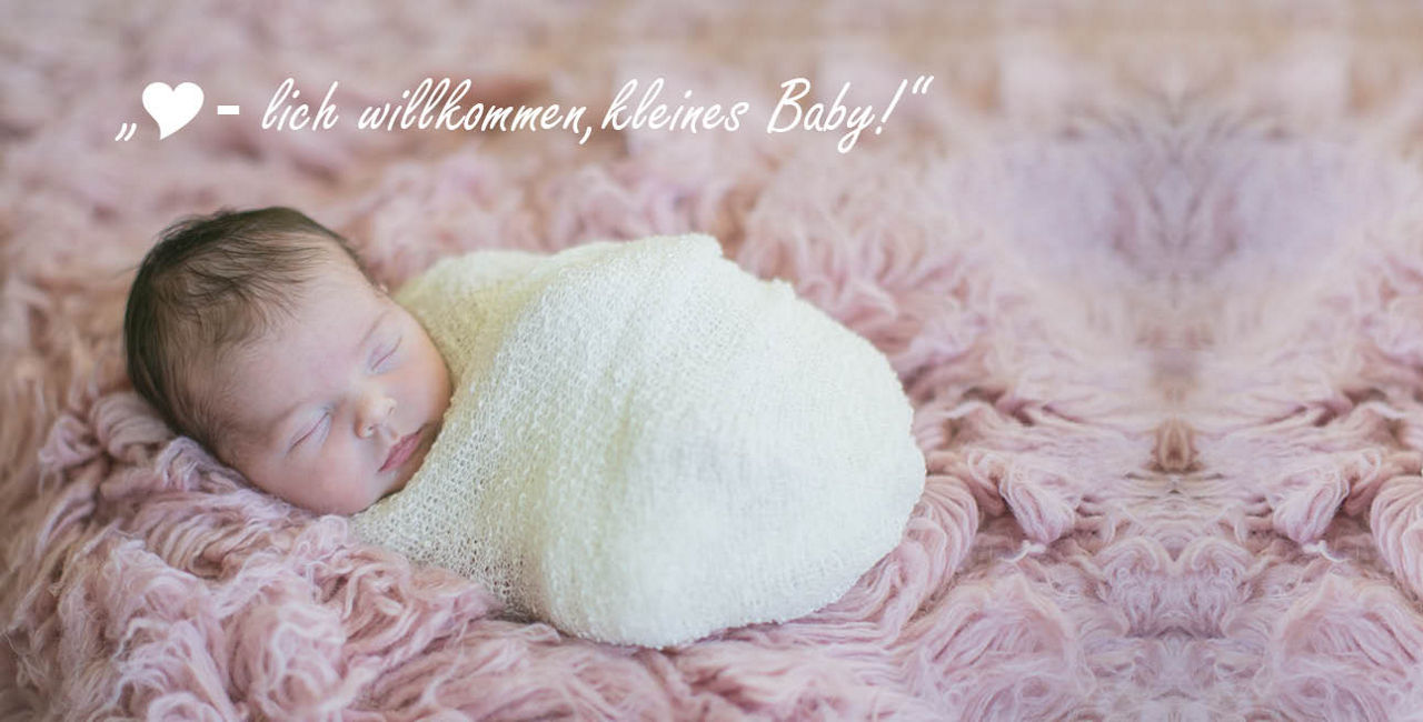 Über dem Baby ist ein Text zu sehen "Herzlich Willkommen kleines Baby"