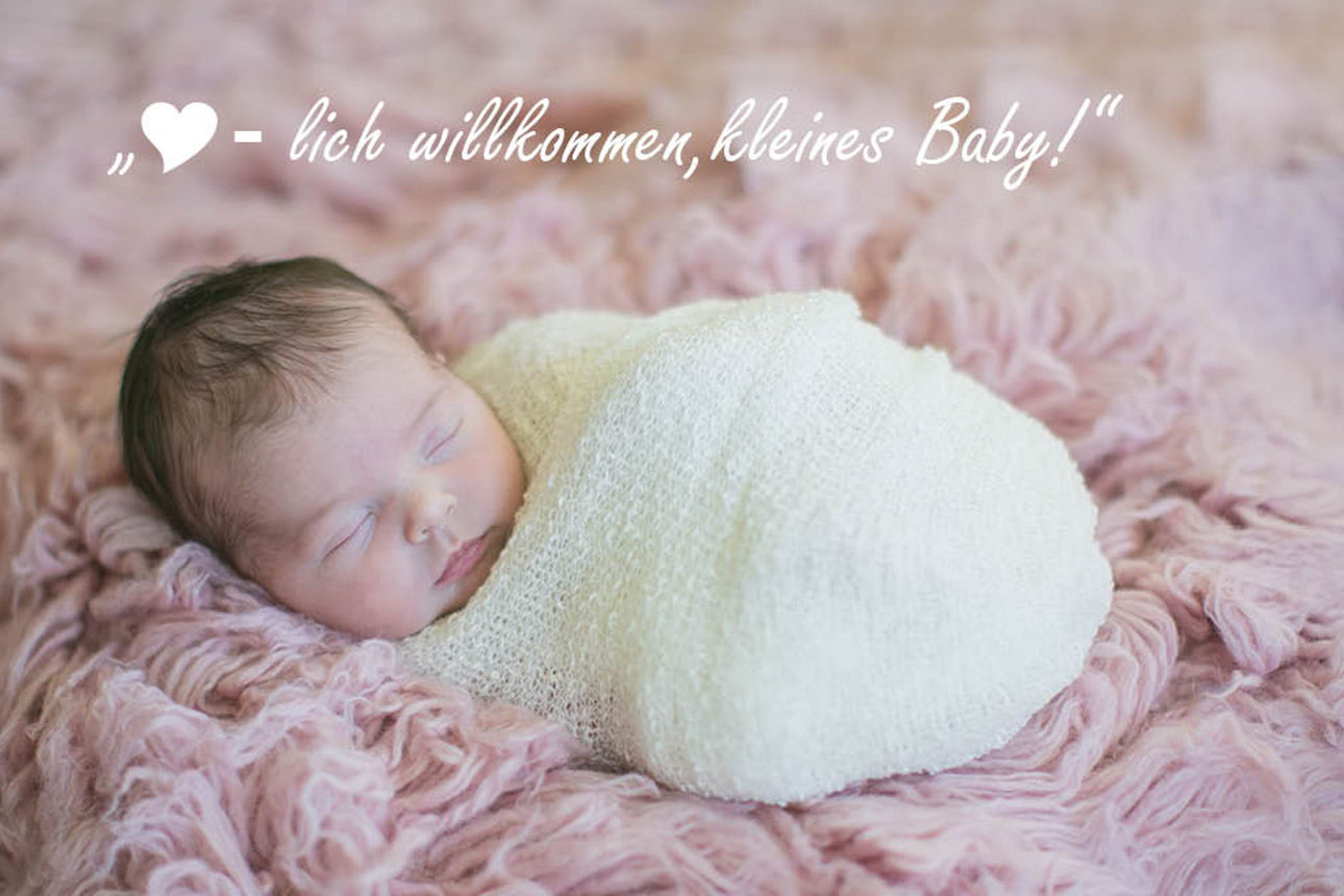 Über dem Baby ist ein Text zu sehen "Herzlich Willkommen kleines Baby"