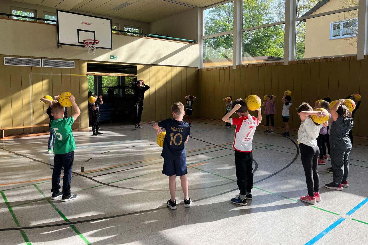 Kinder spielen am Ballaktionstag mit gelben Bällen