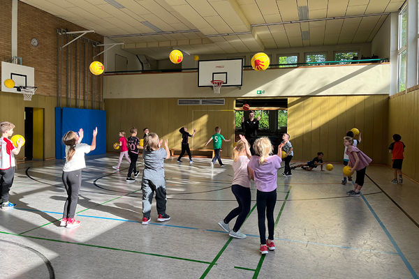 Die Kinder der Grundschule Rentweinsdorf machen Sport-Übungen mit gelben Bällen