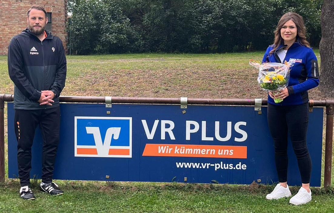 Bandenwerbung beim Rossauer Sportverein SV links von der Werbung steht ein Mann und rechts eine Frau